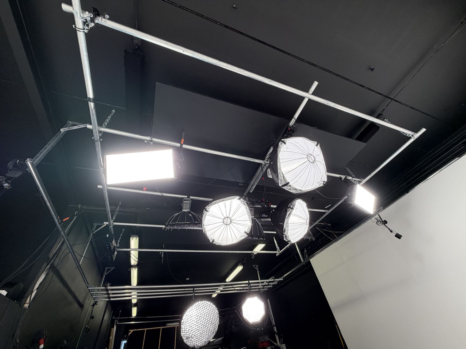 The moving lighting grid on rails with softboxes and panel lights